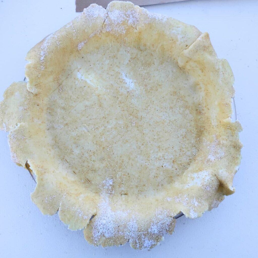 Unbaked pie shell with a rough edge that has not been trimmed yet.