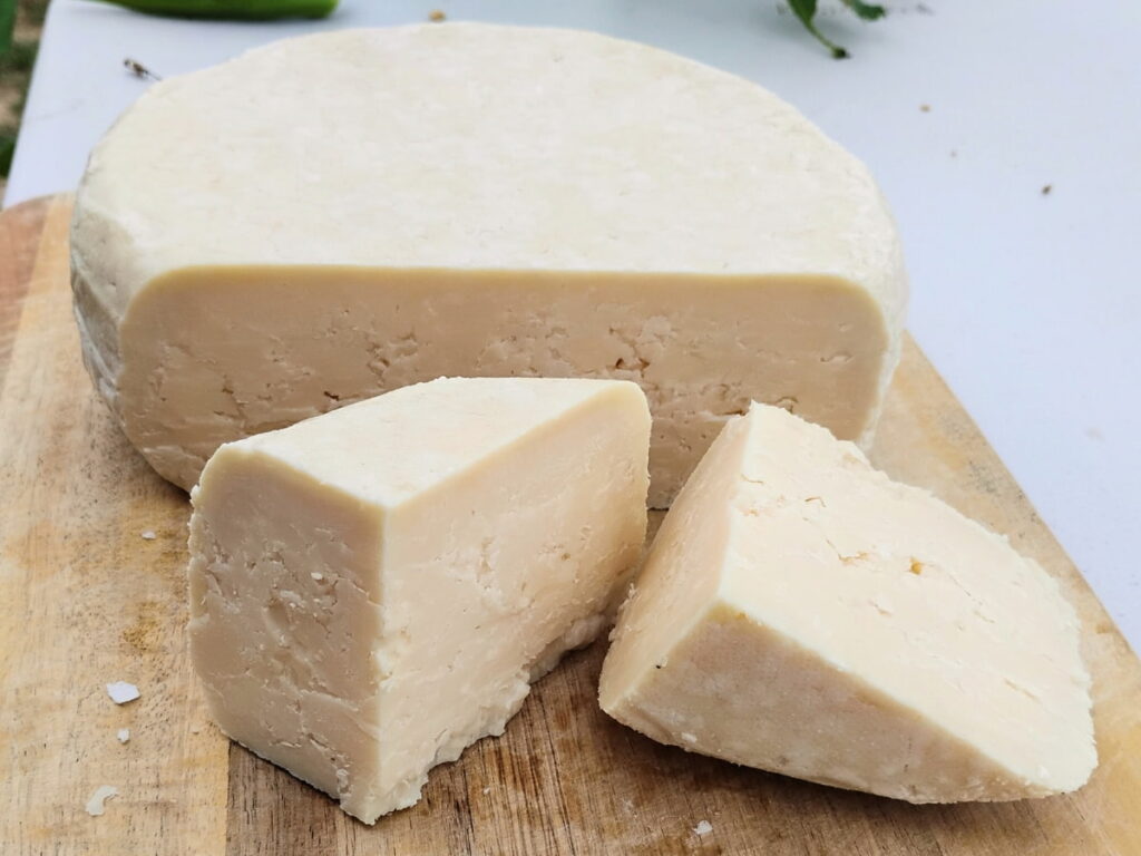 3 year aged cheddar wheel with a few pieces cut off. 