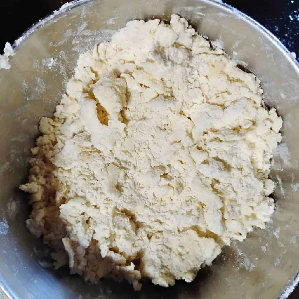 A bowl with flour and butter squished into flakes.