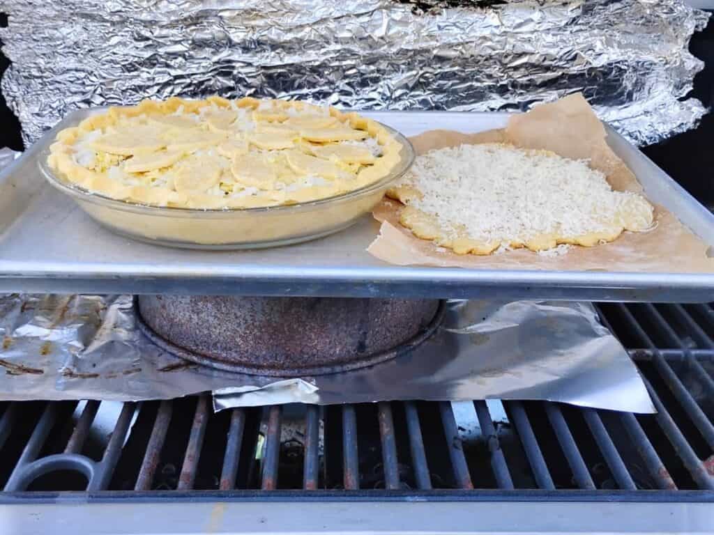 baking a jalapeno pie on a bbq grill with the pie plate and some leftover dough sitting on a sheet that is elevated from the bottom grate. 