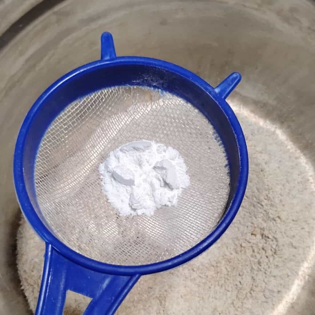 spices and leavening are getting added to fresh milled einkorn and spelt flour in a bowl.