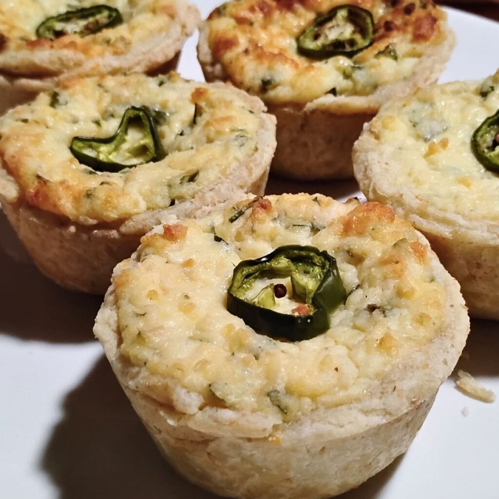 finished jalapeno popper quiche cups arranged on a plate. 
