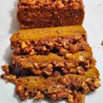 photo of a loaf of sourdough pumpkin coffee cake with some slices showing off the apple pecan and ginger streusel in front.