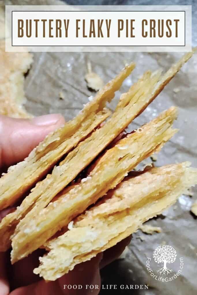 photo shows a hand holding a stack of flaky pie crust shards with text overlay  that reads buttery flaky pie crust, food for life garden.