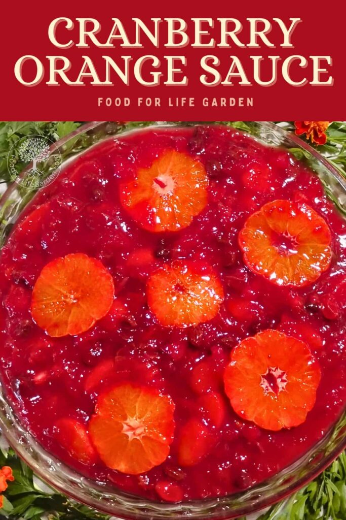 A pie plate with cranberry orange sauce in it and surrounded with parsley and marigolds.
