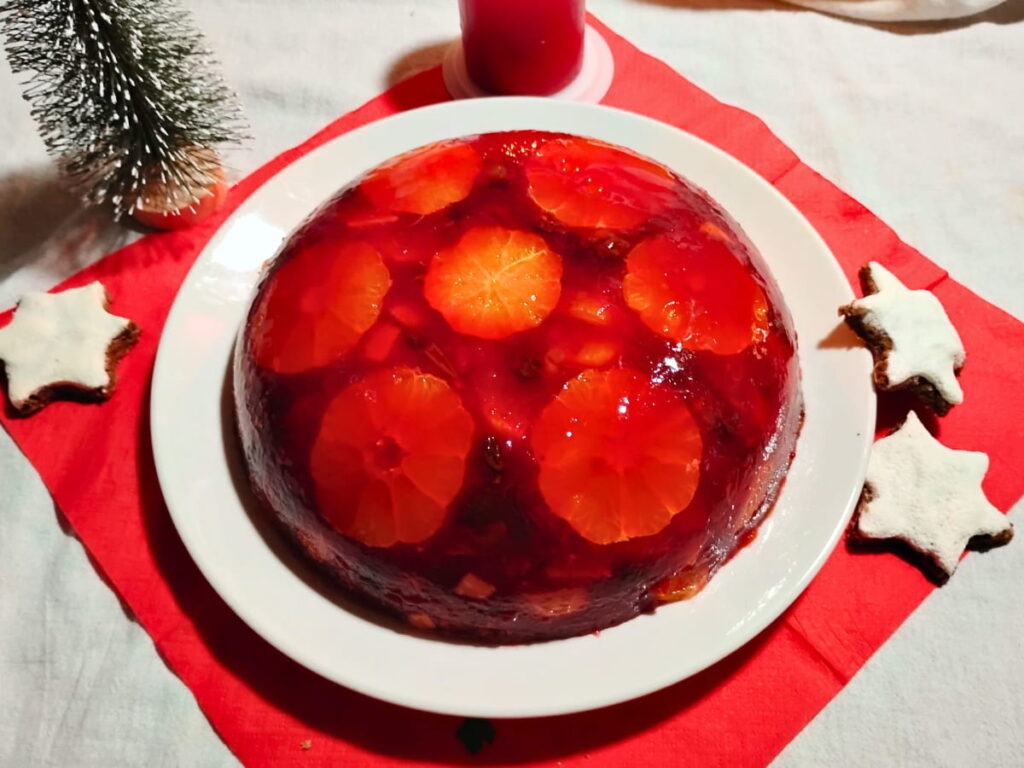 photo shows a plate with an inverted congealed cranberry and orange salad and some cinnamon stars.