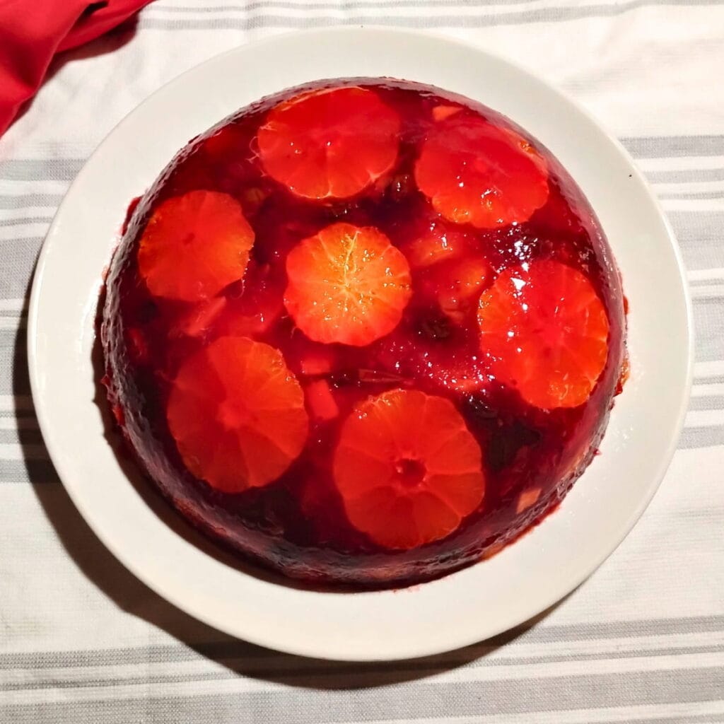 A plate with an un-molded congealed cranberry orange salad.