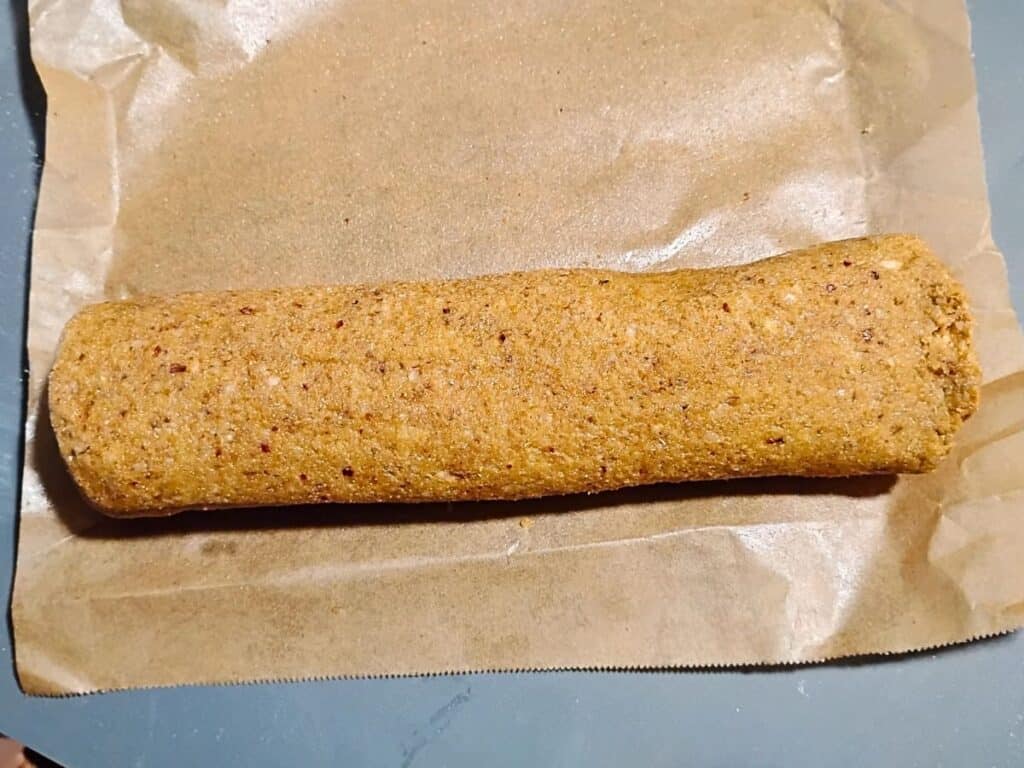 a roll of cookie dough on a piece of parchment paper.