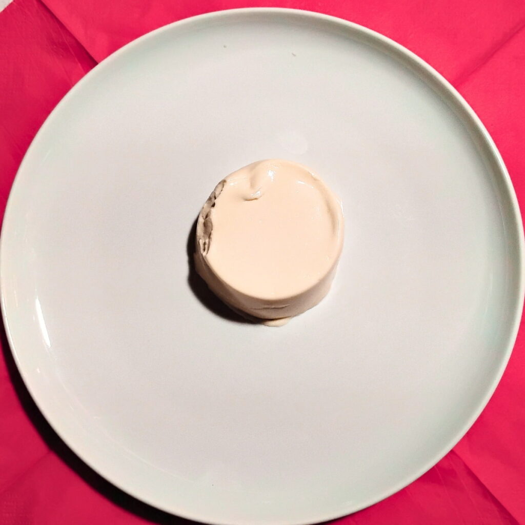 a single panna cotta serving that has just been un-molded onto a plate.