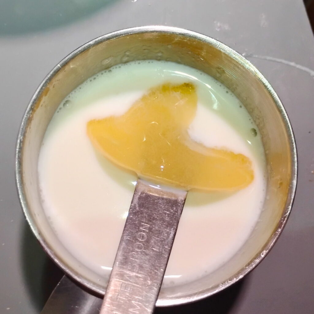 dissolving the bloomed gelatin in the warmed milk.
