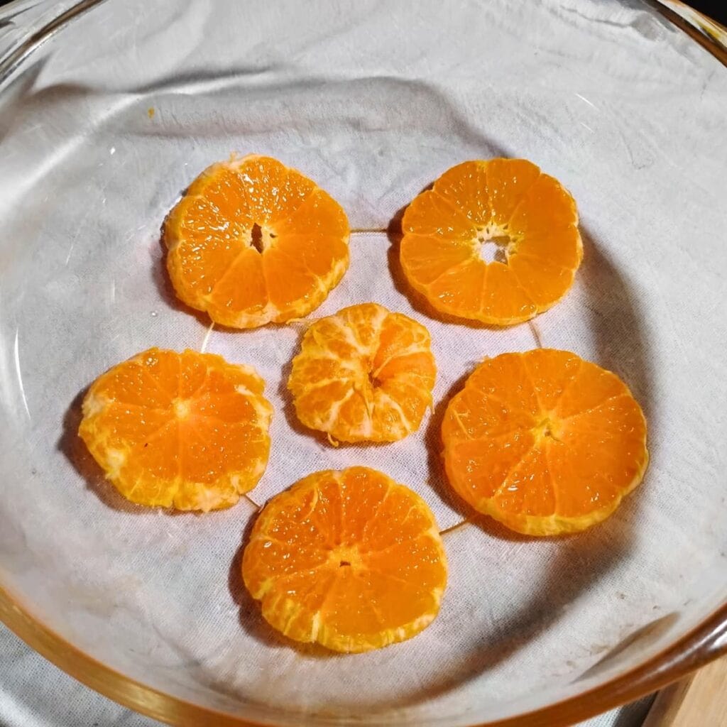 mandarin slices are arranged on the bottom of a rounded dish.