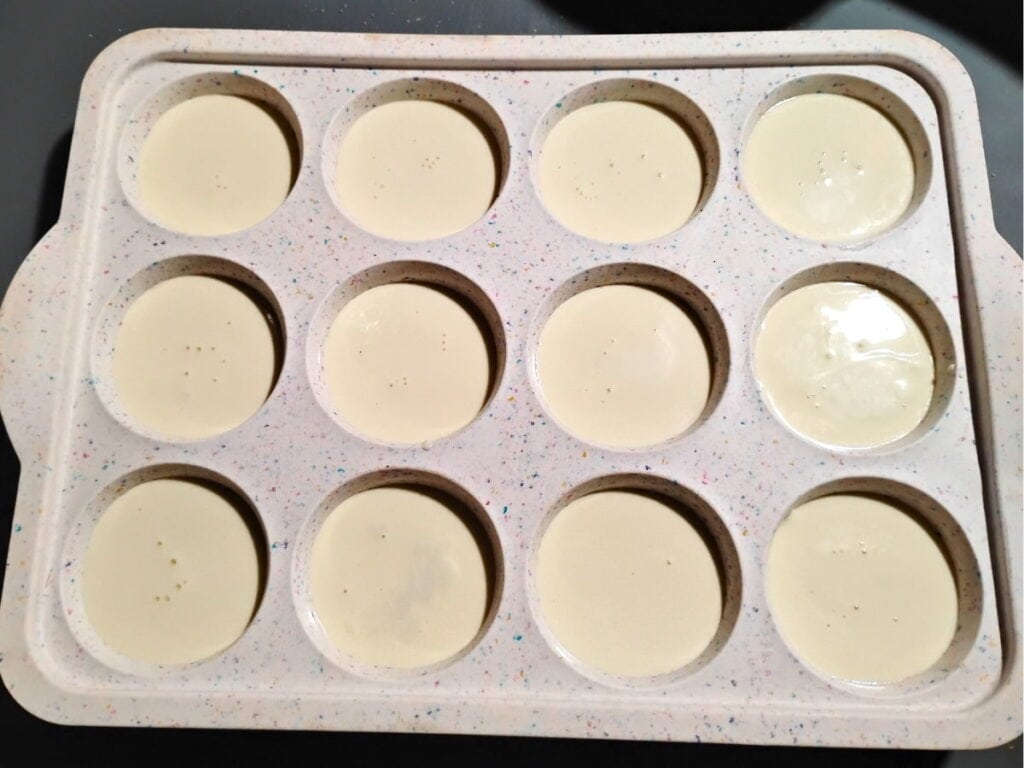 a silicone muffin pan filled with panna cotta cream