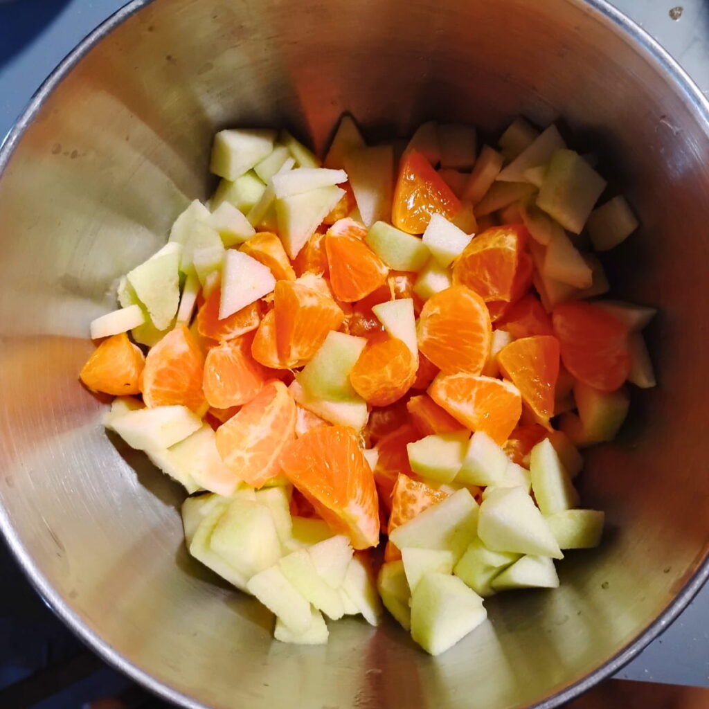 orange sections and apple pieces in a bowl.