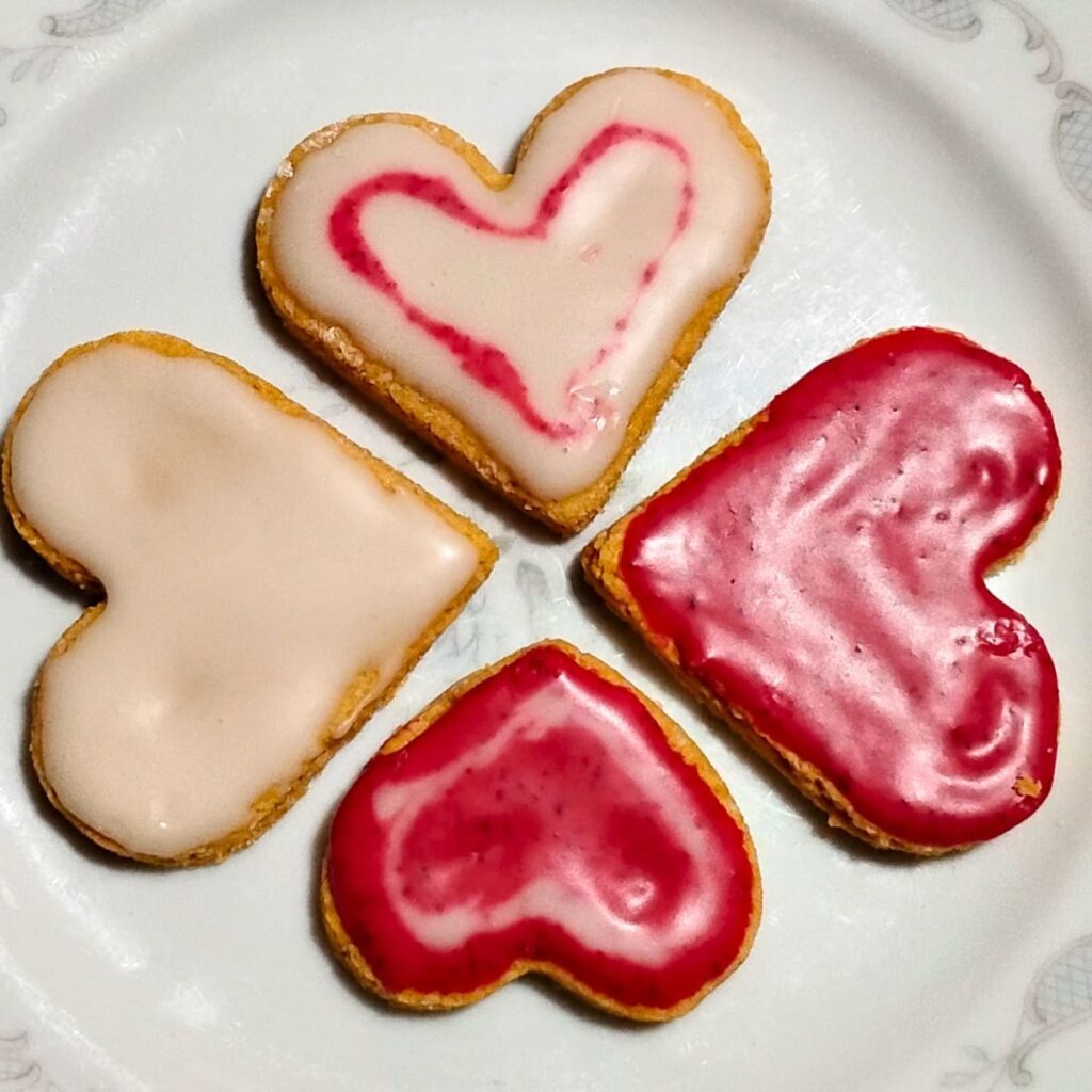4 iced lemon heart cookies on a plate.