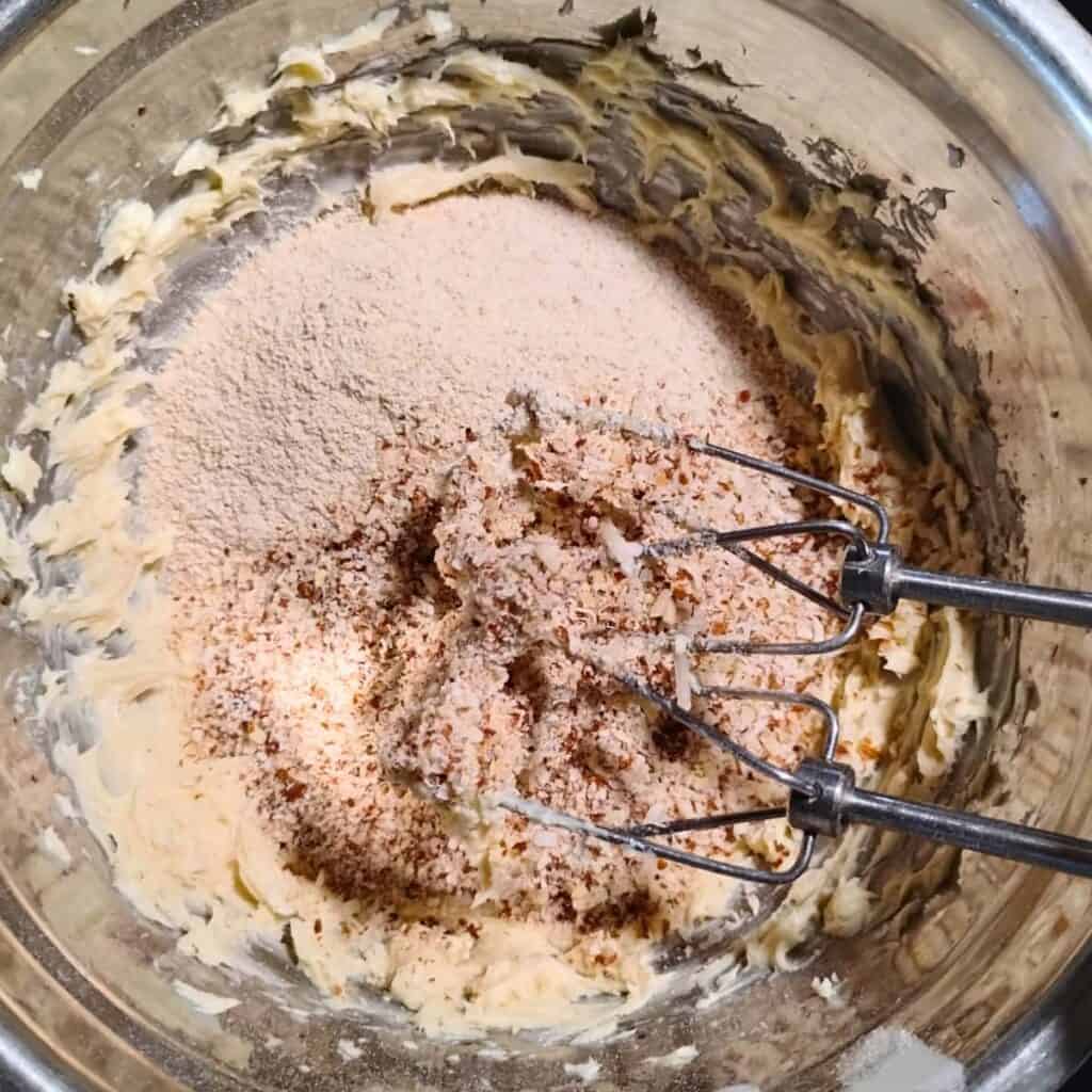 flour and nuts are added to creamed butter and sugar.