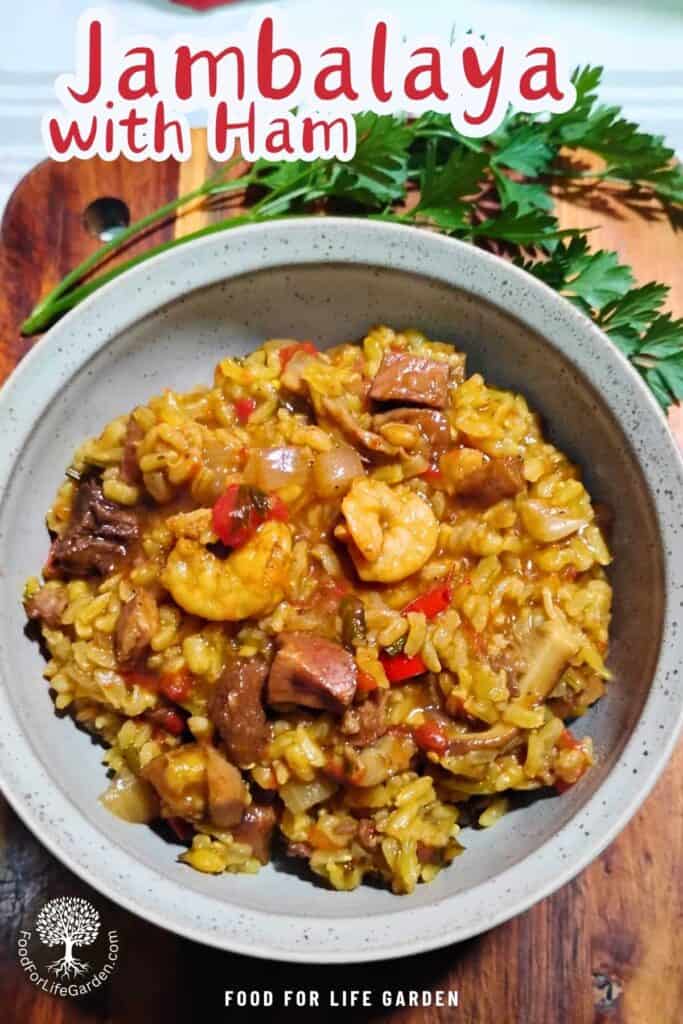 photo shows a bowl filled with shrimp and ham jambalaya and some parsley next to it. text overlay reads jambalaya with ham. food for life garden.