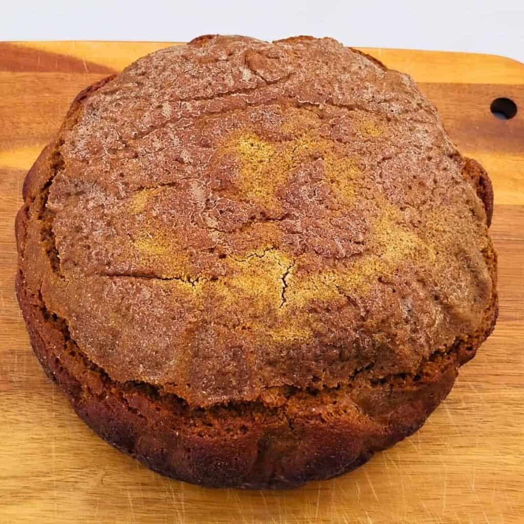 photo of a loaf of sourdough rye bread on a cutting board. 
