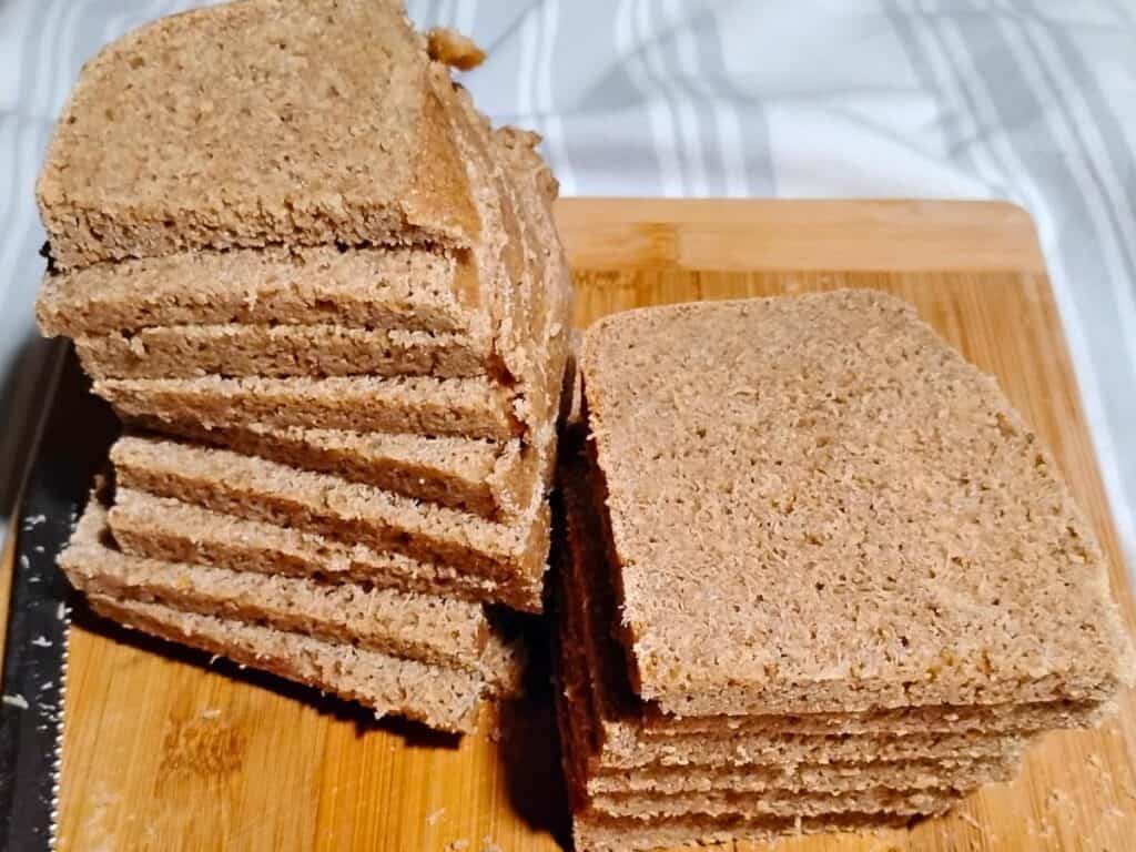 photo of two stacks of sliced sourdough rye bread with kamut and whey, on a cutting board. 