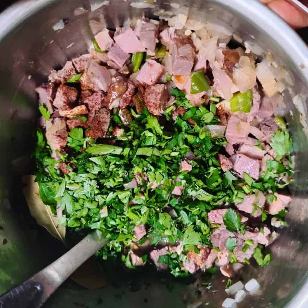 parsley is added to the ham and other ingredients in the pot.