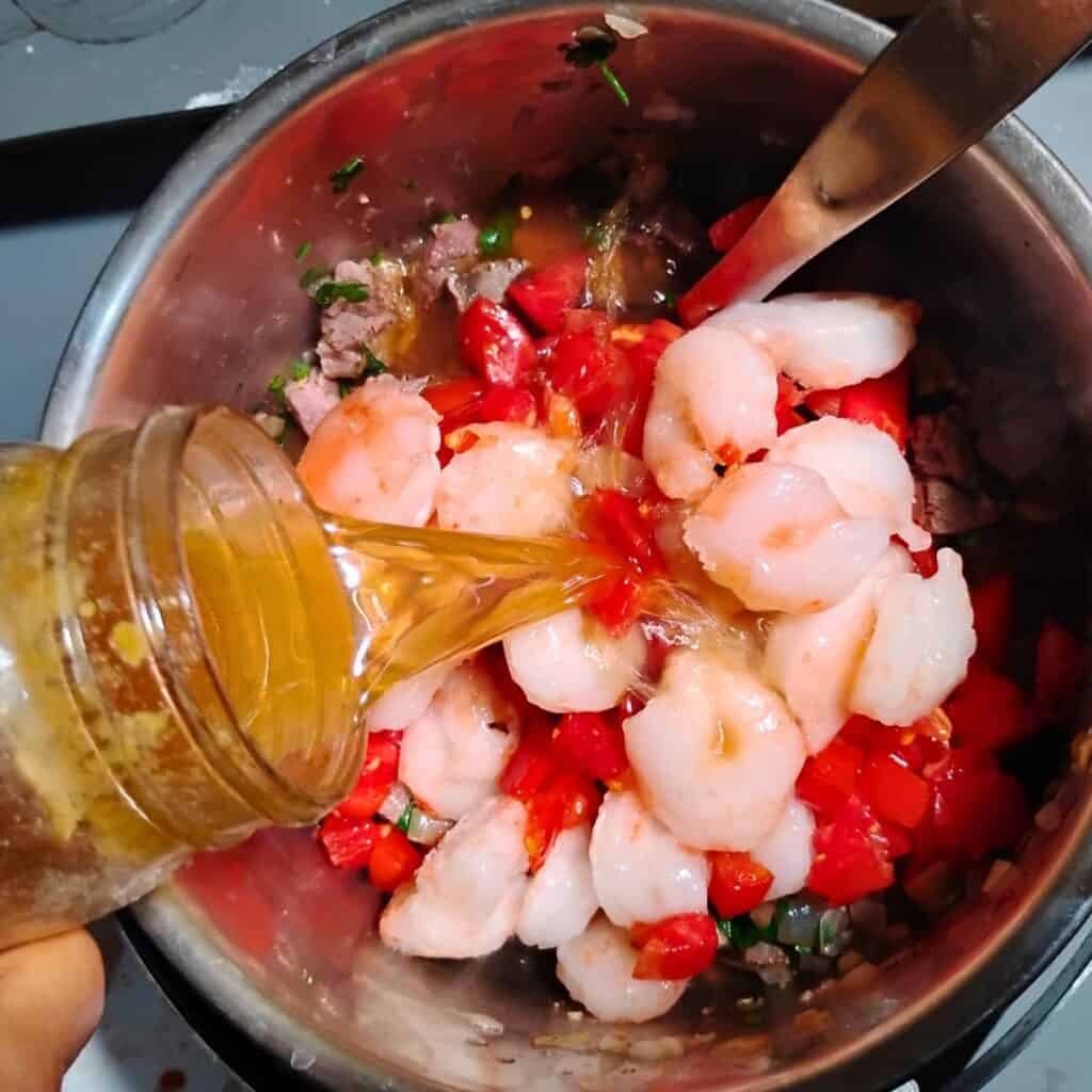 broth is added to the ingredients in a pot.