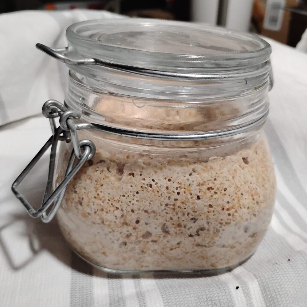 a flip top jar filled with active sourdough starter