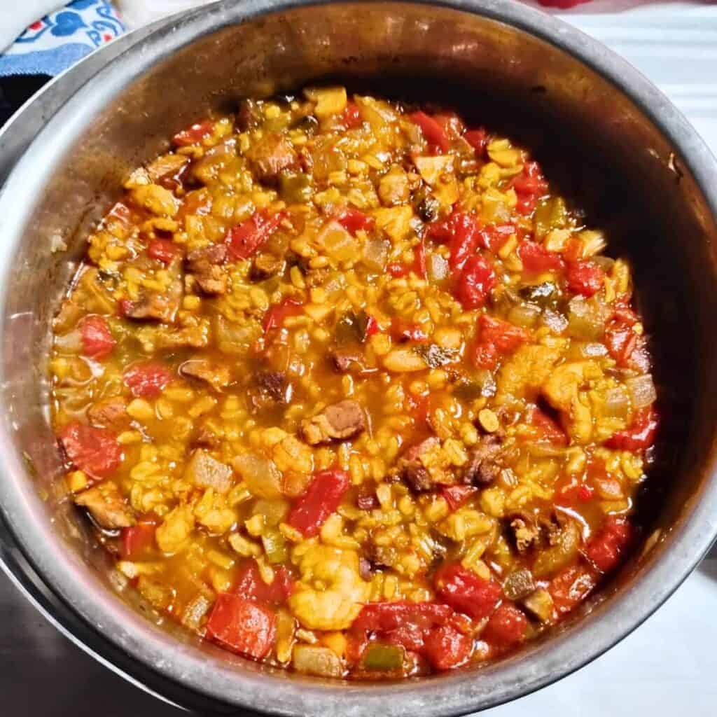 A pot filled with fresh made ham jambalaya with shrimps ready for serving.