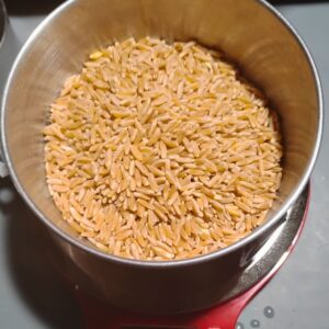 a bowl filled with whole kamut grains on a scale. 
