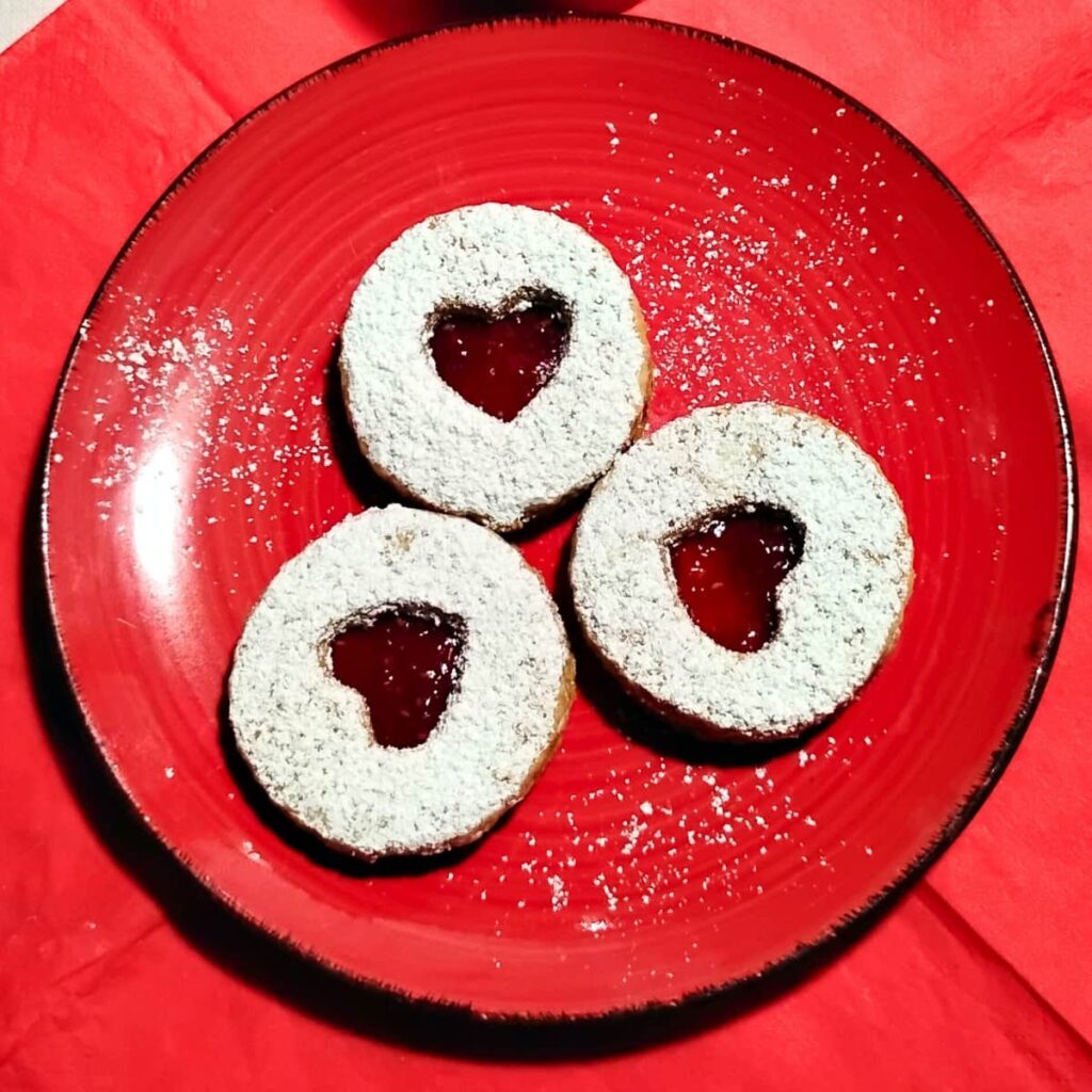 a plate with three cookies with heart cutouts for a valentine's day treat.