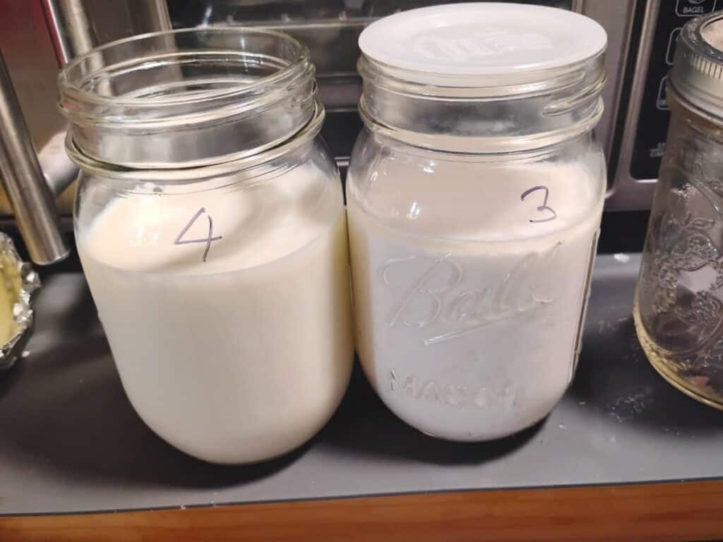 two pint mason jars filled with milk, one is clabbered, the other fresh. it shows the numbers three and four on the jars. 