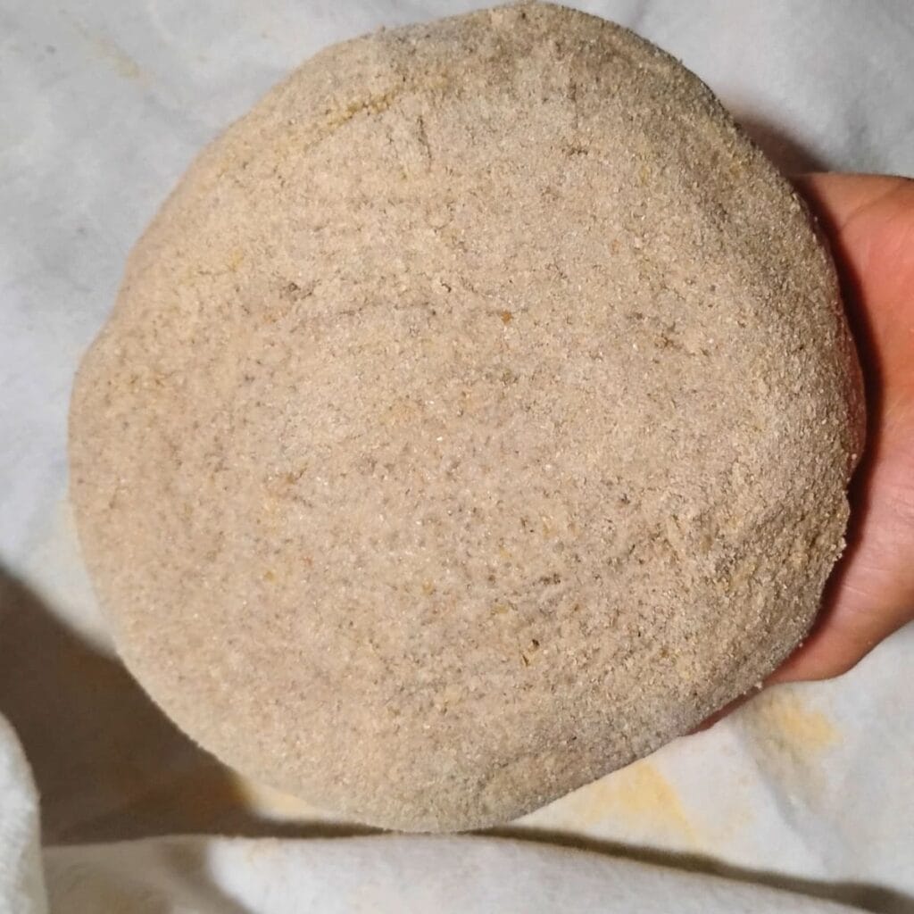 a formed bread dough in a person's hand.