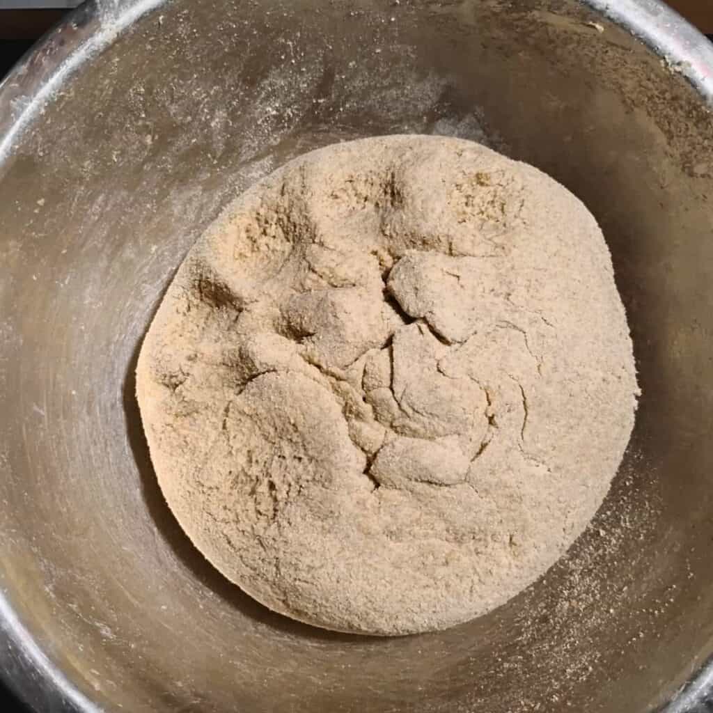 a formed loaf of bread dough in a bowl. 