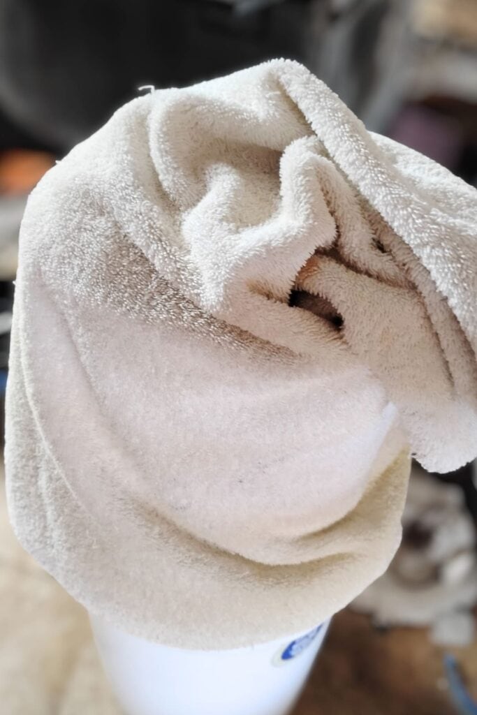 a towel wrapped pot on a bucket.