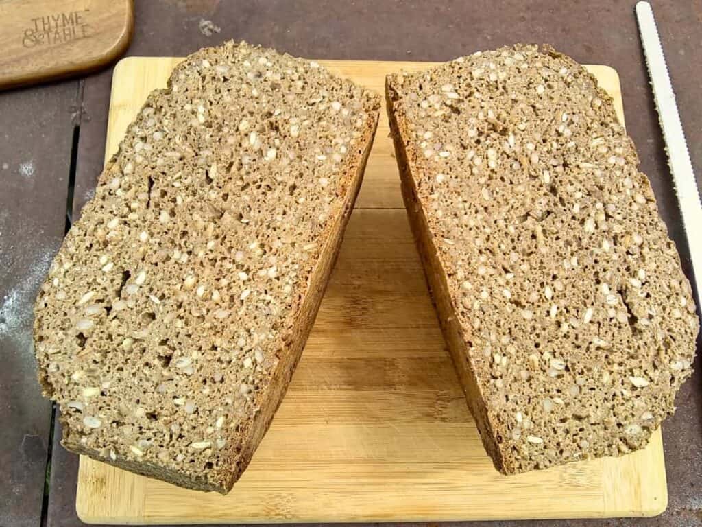 bread loaf cut in half on a cutting board.