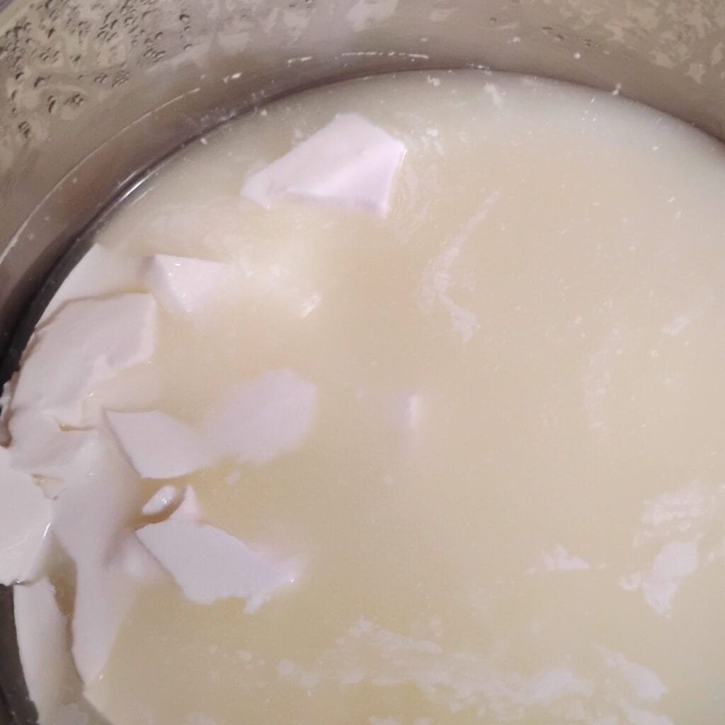 a pot filled with cheese curd pieces in whey