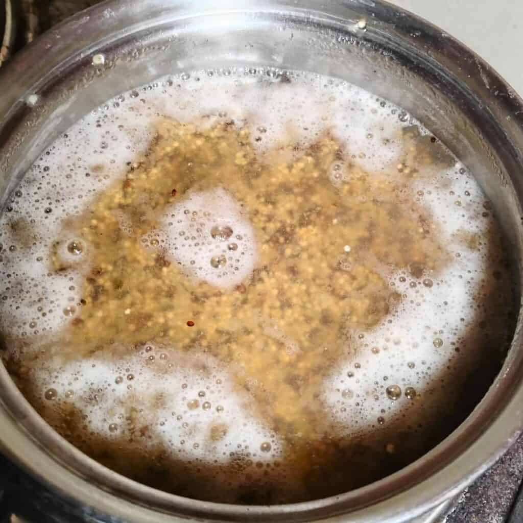 a pot filled with water and quinoa for cooking.