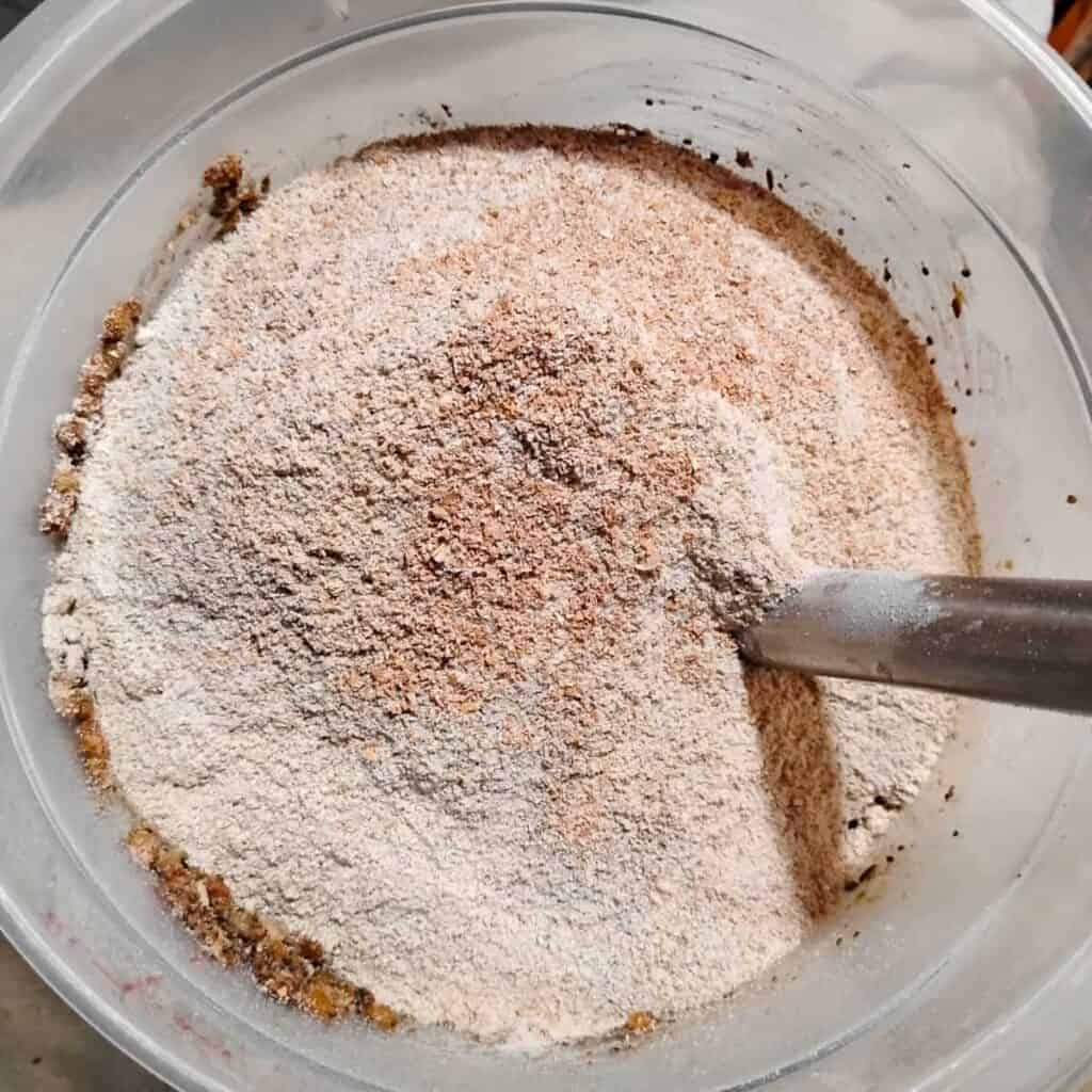 flour was poured over ingredients in a plastic bucket with a dough whisk.